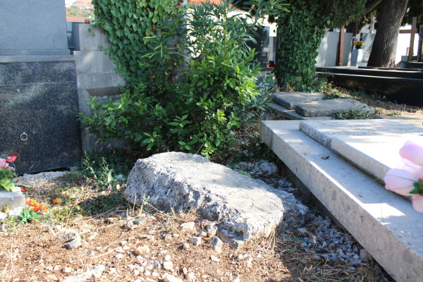 Preostatak stećka - ploče u dijelu starog groblja zapadno od crkve, nakon lomljenja cjelovitog stećka kako bi se dobio prostor i sirovina za izgradnju nove grobnice (Foto: Goran Majetić)