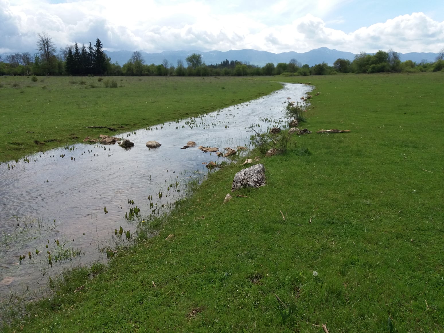 Prijelaz preko Rakića potoka koji se ulijeva u Jadovu. U daljini Velebit.