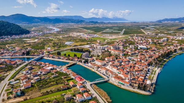 Pogled na Opuzen s istoka: desno Velika Neretva, lijevo Mala Neretva; bivša tvornica PIK-a ”Neretva” nalazila se krajnje desno uz magistralnu cestu (gradsku obilaznicu) (Izvor: Gradonačelnik.hr (gradonacelnik.hr))