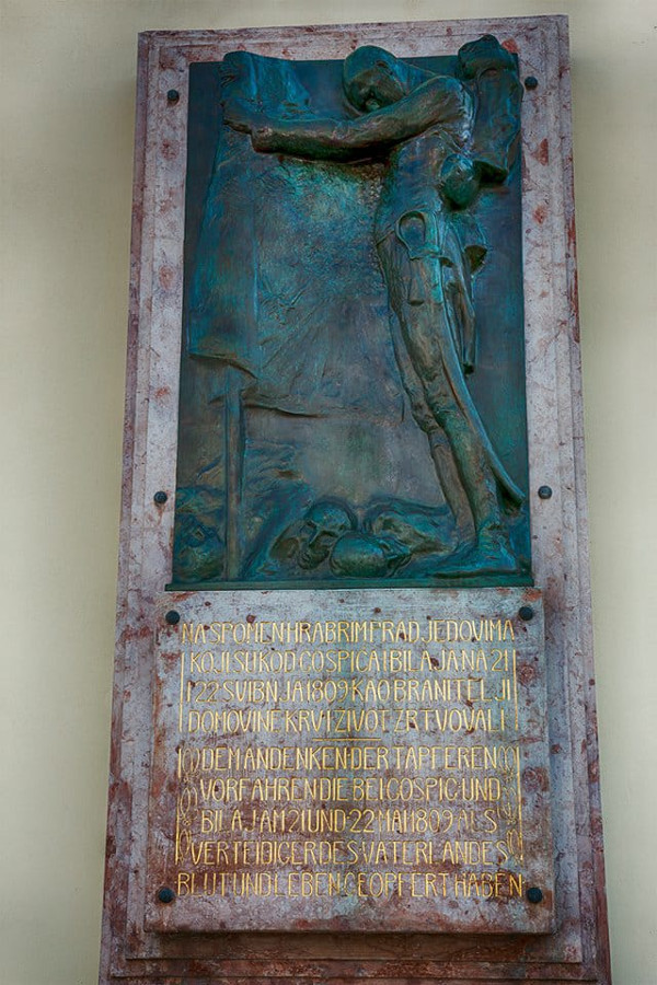 Spomen-ploča (brončani reljef) poginulim hrvatskim braniteljima u bitci kod Bilaja, rad kipara Roberta Frangeša Mihanovića iz 1909. godine, postavljena na župnu crkvu Navještanja Blažene Djevice Marije u Gospiću, s natpisom na njemačkom i hrvatskom jeziku: ”Na spomen hrabrim pradjedovima koji su kod Gospića i Bilaja 21. i 22. svibnja 1809. kao branitelji Domovine krv i život žrtvovali” (Izvor: GS press (gspress.net))