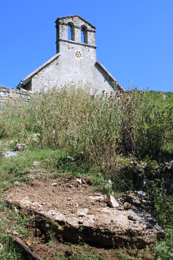 Ogromna, ali okrnjena, kamena ploča koja je nakon građevinskih radova iz 2015. godine s oskrnavljenog starog groblja dospjela na padinu u njegovom podnožju (Foto: Goran Majetić)