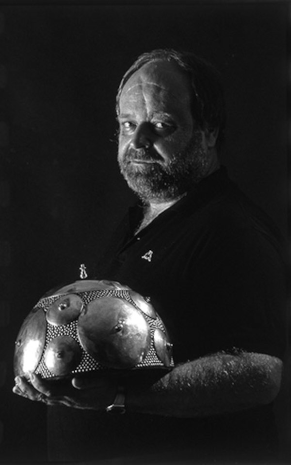 Arheolog Želimir Škoberne, istraživač nekropole u Budinjačkom polju u Žumberačkom gorju, sa velikom ratničkom brončanom zdjelastom kacigom (usporedite veličinu kacige i glave arheologa!) pronađenom u tamošnjem kneževskom tumulu (Foto: Romeo Ibrišević, 2000.; Izvor: Hrvatska enciklopedija (enciklopedija.hr))